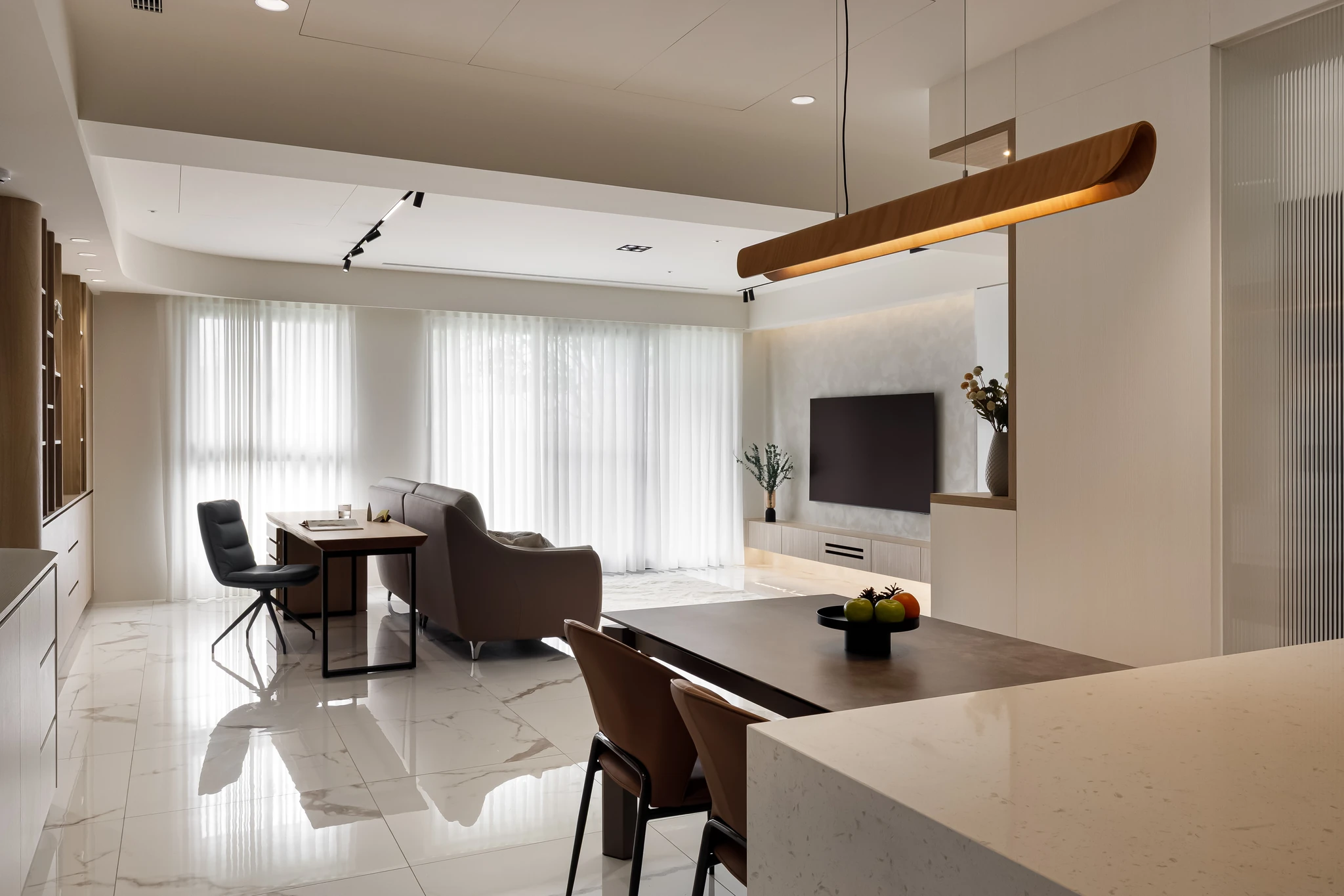 Akuma Design｜惠宇青山清 — 中島視角望向餐廳與客廳，木質線型吊燈懸浮於中島上方，空間層次分明｜空間攝影 / 琢磨影像