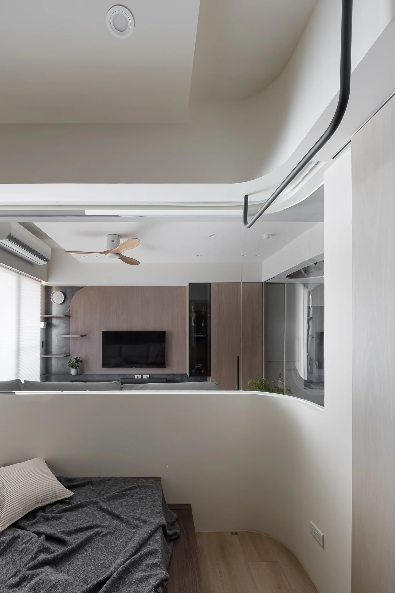 YJ Design|富宇富好 — 臥房透過弧形矮牆望向客廳電視牆與吊扇,白色曲面語彙|空間攝影 / 琢磨影像