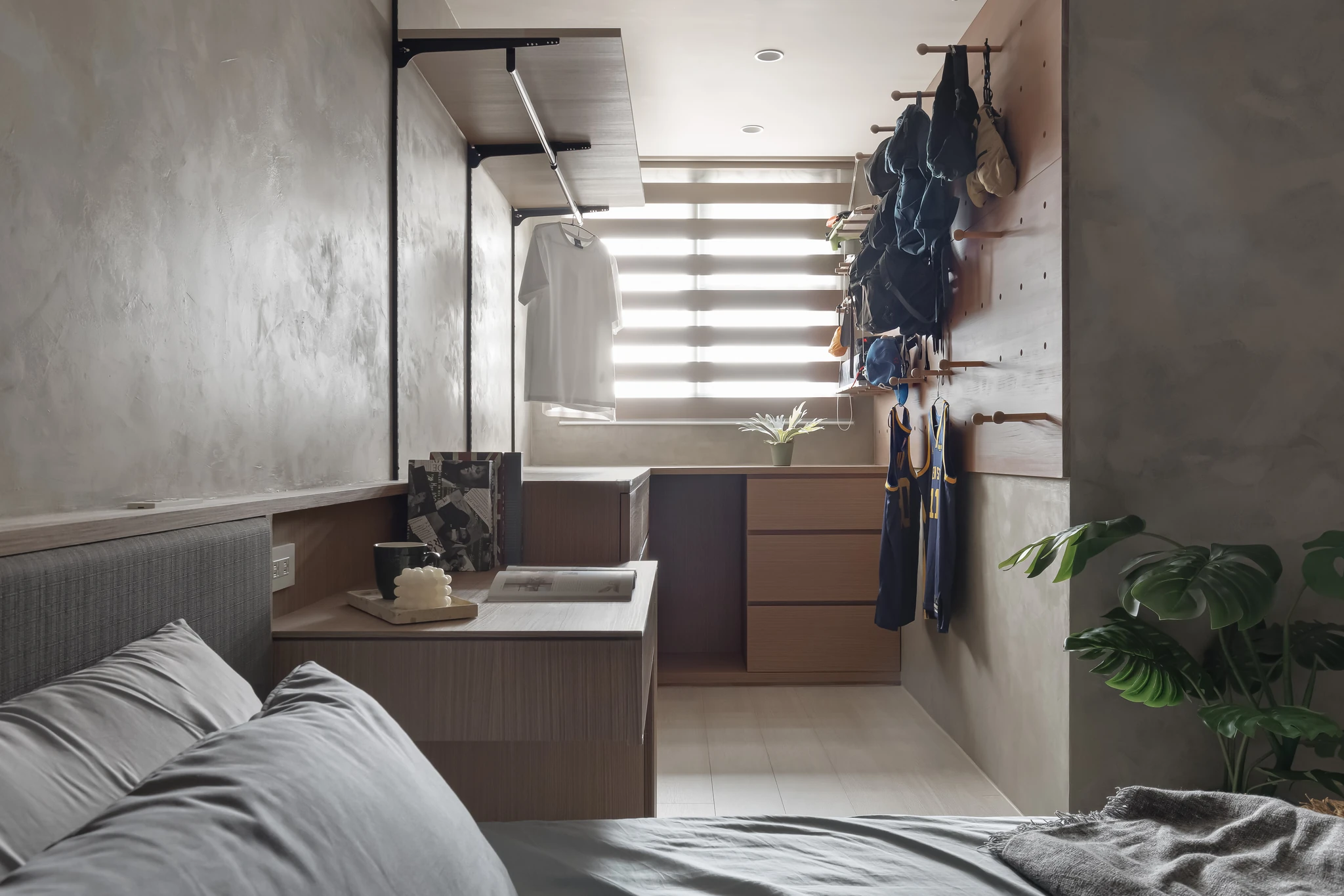 YJ Design｜陽光樹 — 臥室望向更衣區，百葉窗光灑落，洞洞板牆吊掛衣物與木質收納櫃｜空間攝影 / 琢磨影像